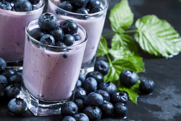 Fototapeta na wymiar Lilac homemade yogurt with blueberries on a dark background, sel
