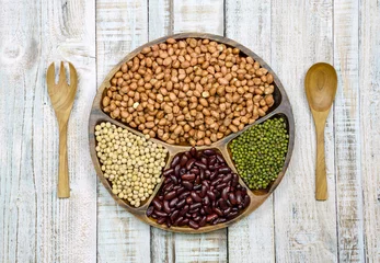 Foto op Canvas Collection of cereals, beans and grains on wood background © naughtynut