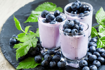 Fototapeta na wymiar Lilac homemade yogurt with blueberries on a dark background, sel