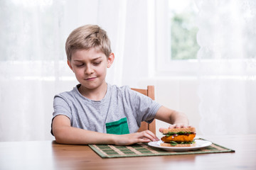 Fussy kid with chicken sandwich