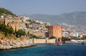 Fototapeta na wymiar Wall of fortress and Red Tower (Kizilkule) in Alanya, Turkey 