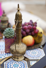 Wedding table arrangement in desert sand of Morocco stile. Fresh grapes near the salver with apples and pears