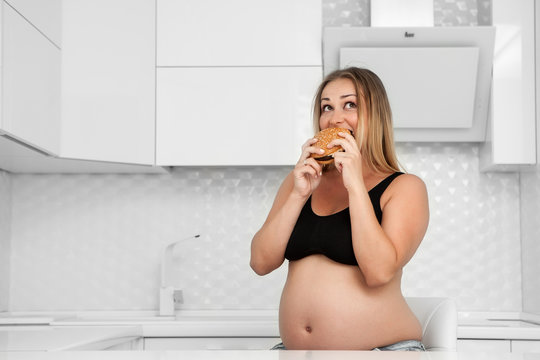 Pregnant eats a hamburger