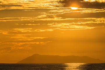 Ionian sea sunset with orange color and island on the background