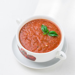 Tomato gazpacho soup in white bowl.