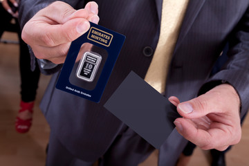 Businessmann anonym zeigt Silber Barren und Visitenkarte 