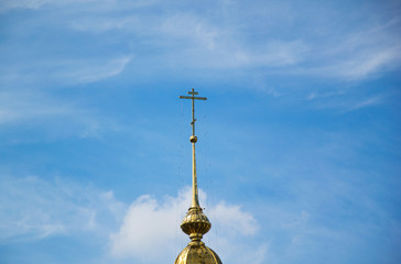 Fototapeta na wymiar Orthodox cross on a gold dome of church against the sky
