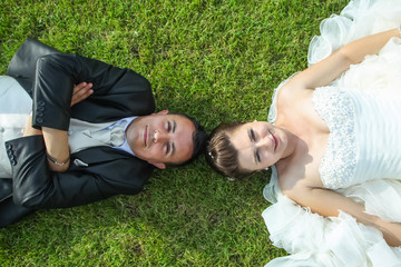Bride and groom posing on grass
