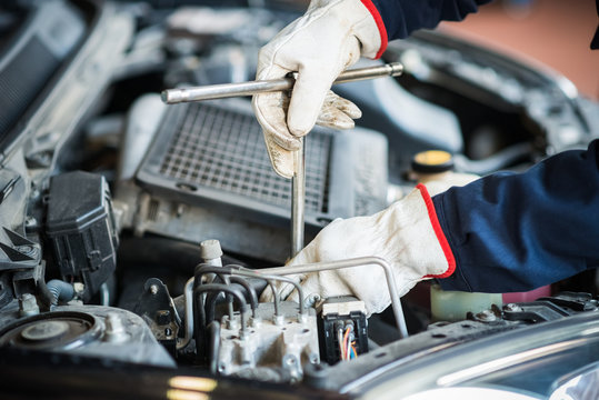 Detail of a mechanic at work on a car engine