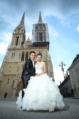 Obraz premium Newlyweds holding hands in city