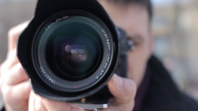 Man with the camera adjusts the focus on the fixed lens