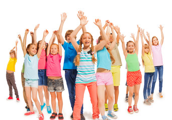 Fototapeta premium Many happy kids together raise hands up in the air