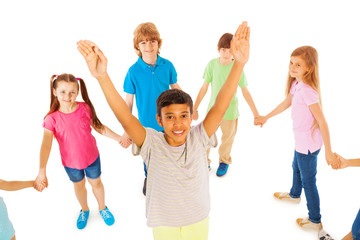Boy with lifted hands stand in circle of friends