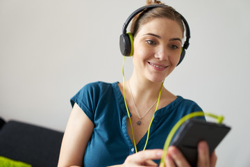Woman With Green Earphones Listens Podcast Music On Telephone