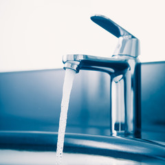 faucet with flowing water, blue tone