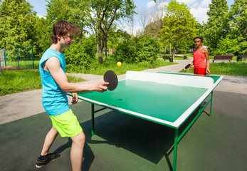 African girl and boy playing ping pong outside - obrazy, fototapety, plakaty