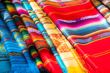 Colorful Mexican serapes hang in row