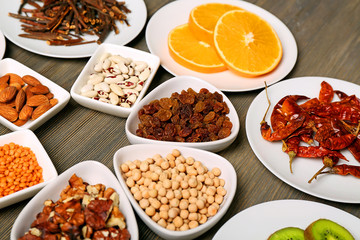 Different products on saucers on wooden table, closeup