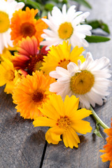 Bright wildflowers on wooden table, closeup