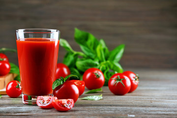 Glass of tomato juice with vegetables on wooden table close up