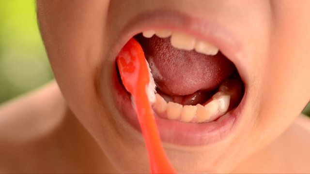Close up boy brush tooth on green bokeh background
