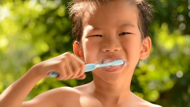 Close up boy brush tooth on green bokeh background