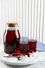 Sweet homemade cherry compote on table, on light background