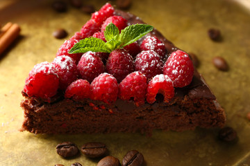 Piece of cake with Chocolate Glaze and raspberries on tray, close-up
