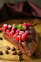 Piece of cake with Chocolate Glaze and raspberries on tray, close-up
