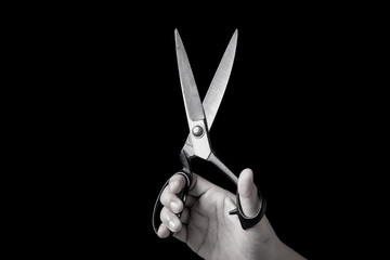 Black and White scissors on hand isolated on black background
