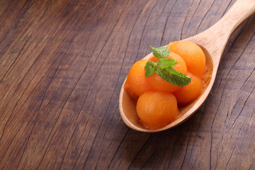 Organic cantaloupe melon in wooden spoon on wooden table