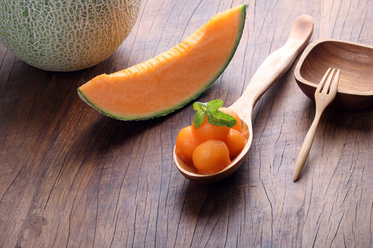 Organic cantaloupe melon in wooden spoon on wooden table