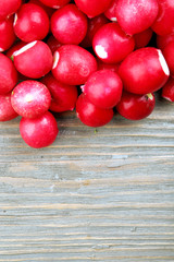 Naklejka na ściany i meble Heap of fresh radishes on wooden table close up background
