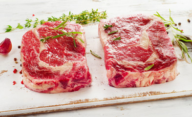Raw rib eye Steaks  on a cutting board.