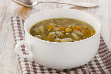 Bowl of Soup with Lentils, Beans, Chicken and Vegetables on a wo