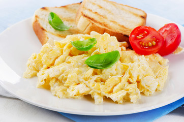 Scrambled eggs with fresh basil and tomatoes.