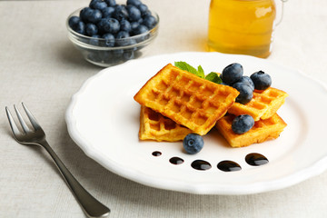 Sweet homemade waffles with forest berries and chocolate sauce on table background