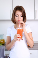 Young beautiful woman drinking apple juice