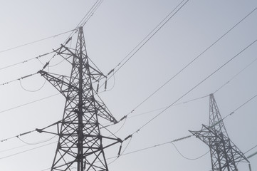 Electric high voltage power towers at morning mist