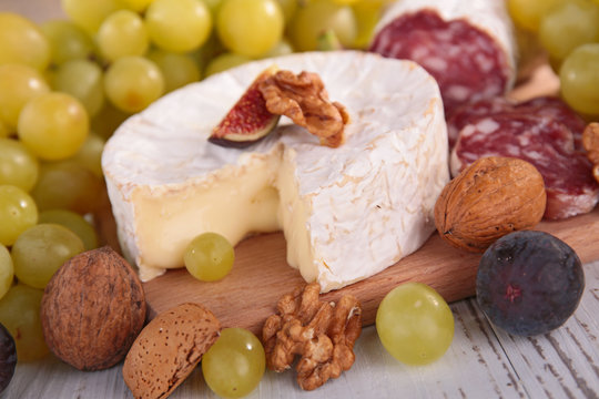 cheese with grape and nut on board