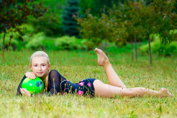 outdoor portrait of young cute little girl gymnast training with