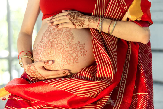 The pregnant woman belly with henna tattoo
