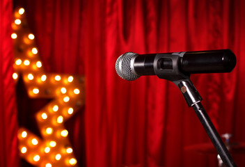 microphone on theater stage ,golden star on background  with red curtains 
