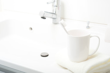 洗面台に置かれた歯ブラシとコップ