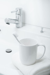 洗面台に置かれた歯ブラシとコップ