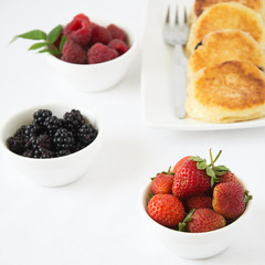 Homemade cheesecakes with berries on white background