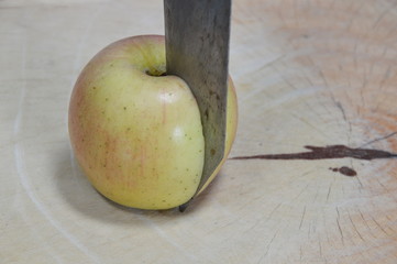 knife cut on apple on wooden chop block