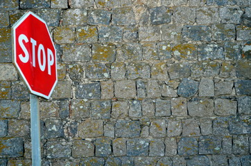 Stop-Schild vor historischer Mauer