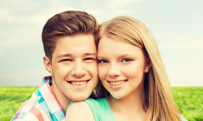 smiling couple hugging over natural background