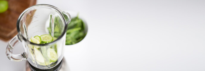 close up of blender jar and green vegetables
